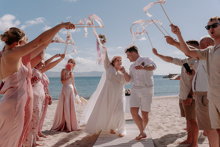 para młoda i goście na ślubie na plaży