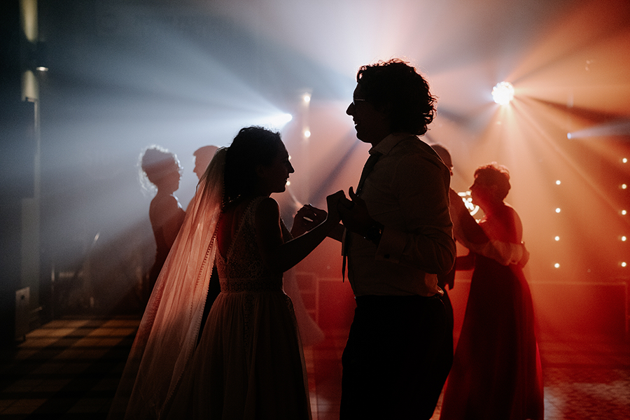 para młoda tańczy na tle kolorowych świateł