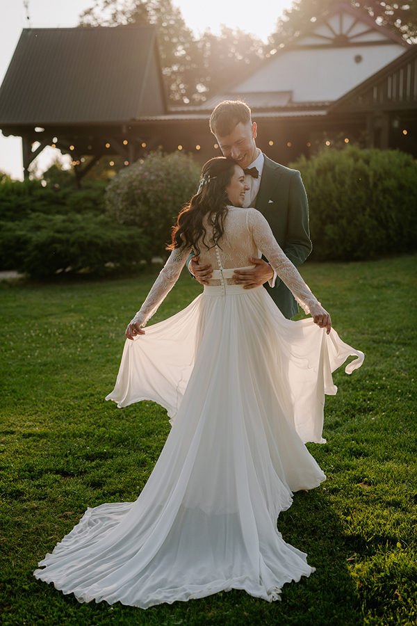Para młoda z rozwianą suknią w zielonym ogrodzie